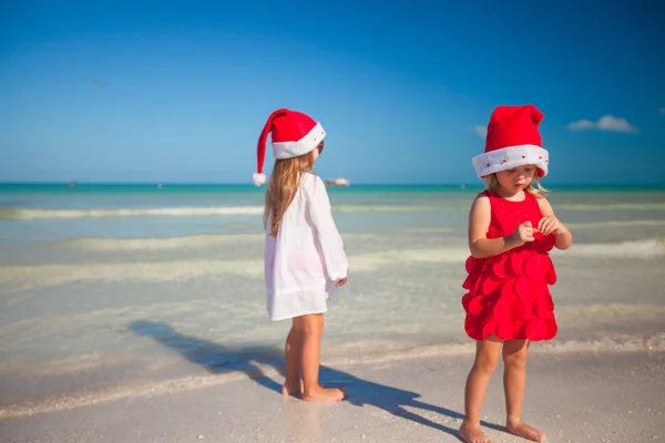 Meninas bonitos em chapéus de Natal na praia exótica — Fotografia de Stock